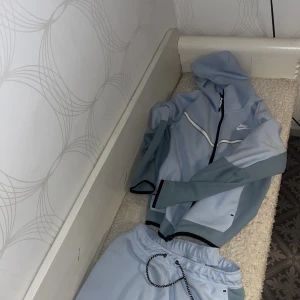 Ljusblå Nike tech - Säljer nu min ljusblåa Nike tech som jag inte använda mycket. Byxorna är i storlek Large men passar Medium och tröjan är i Medium. 
