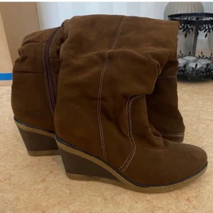 Stövlar  - Säljer dessa otroligt fina kilklacks stövlarna. Skorna är höga men du kan ändra längden beroende på hur du vill att dom ska sitta. Färgen är choklad brun skulle jag säga🫶🏽   Hör gärna av er om ni är intresserade, tryck inte på köp direkt🫶🏽