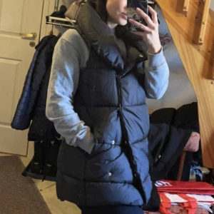 Väst NAKD - Sjukt fin lång väst med krage från NA-KD. Fler bilder kan fås!   Slutsåld men länk: https://www.na-kd.com/sv/produkter/vadderad-vast-med-hog-krage-svart   Stor i storlek