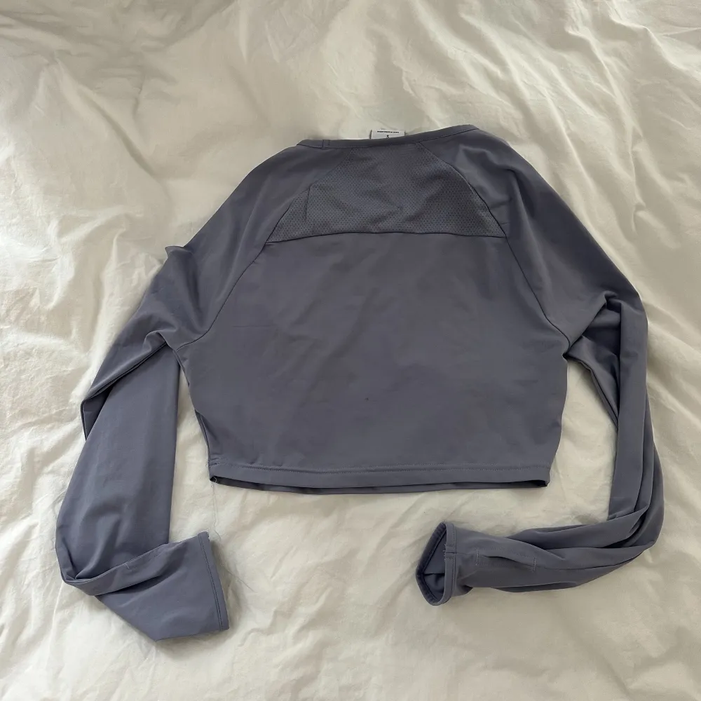 Gymshark crop top i storlek S, köpt i USA för 2 år sedan. Använd 1 gång, annars bara legat i garderoben. . Toppar.