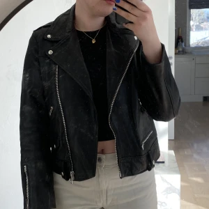 Skinnjacka från Allsaints 🖤 - Bikerjacka i läder av högsta kvalitet. Från Allsaints. Storlek 40, men liten i storleken så mer som 36/38 eller 34 om man vill ha mer oversize. I bra skick! Dock saknas bältet i midjan vilket reflekteras i priset.Inköpt för ca 4000kr.