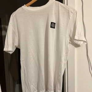 Stone island tshirt  - Vit snygg T-shirt   Obs pyttelitet hål i