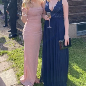 Balklänning rosa glittrig small/medium - En jättefin rosa balklänning med slits som köptes i USA från märket ”windsor” som jag hade på studentbalen❣️ passar small/medium. Jag är 160 cm och hade klackskor och då gick den fortfarande ner på marken så den passar någon som är lite längre än mig! 