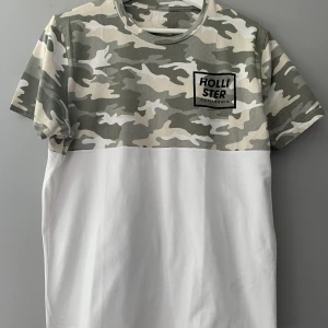 T-shirt  - Fin T-shirt från Hollister delvis i  kamouflagemönster! Tröjan är använd ett fåtal gånger och i fint skick. 