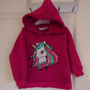 Hoodie unicorn 98/104 - Ceriserosa hoodie med paljettmotiv av unicorn. Strl 98/104. Fint skick 