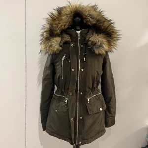 Zara Jacka - Nyskick!! Vinterjacka i mörkgrön färg med riktigt varmt fuskpäls på insidan.