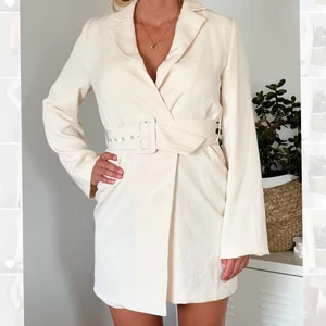 Festklänning  - Äggvit festklänning i kavaj-stil. Inköpt på NA-KD för två år sedan. Använd en gång. 