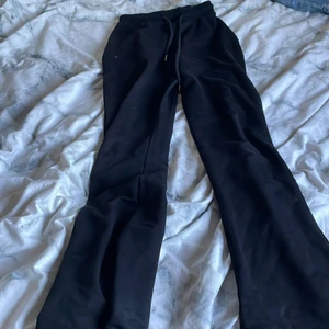 Svarta utsvängda byxor  - Ett par svarta utsvängda byxor från Nelly i mjukis material. Byxorna har snören på sig, materialet är väldigt tunt på byxorna. De är i storleken xxS, ganska långa och går över fötterna på mig som är 150. Byxorna är använda i 2 månader ungefär och är i bra skick. Kostar 100kr+frakt.