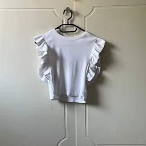 En vit tröja från zara med volangarmar 