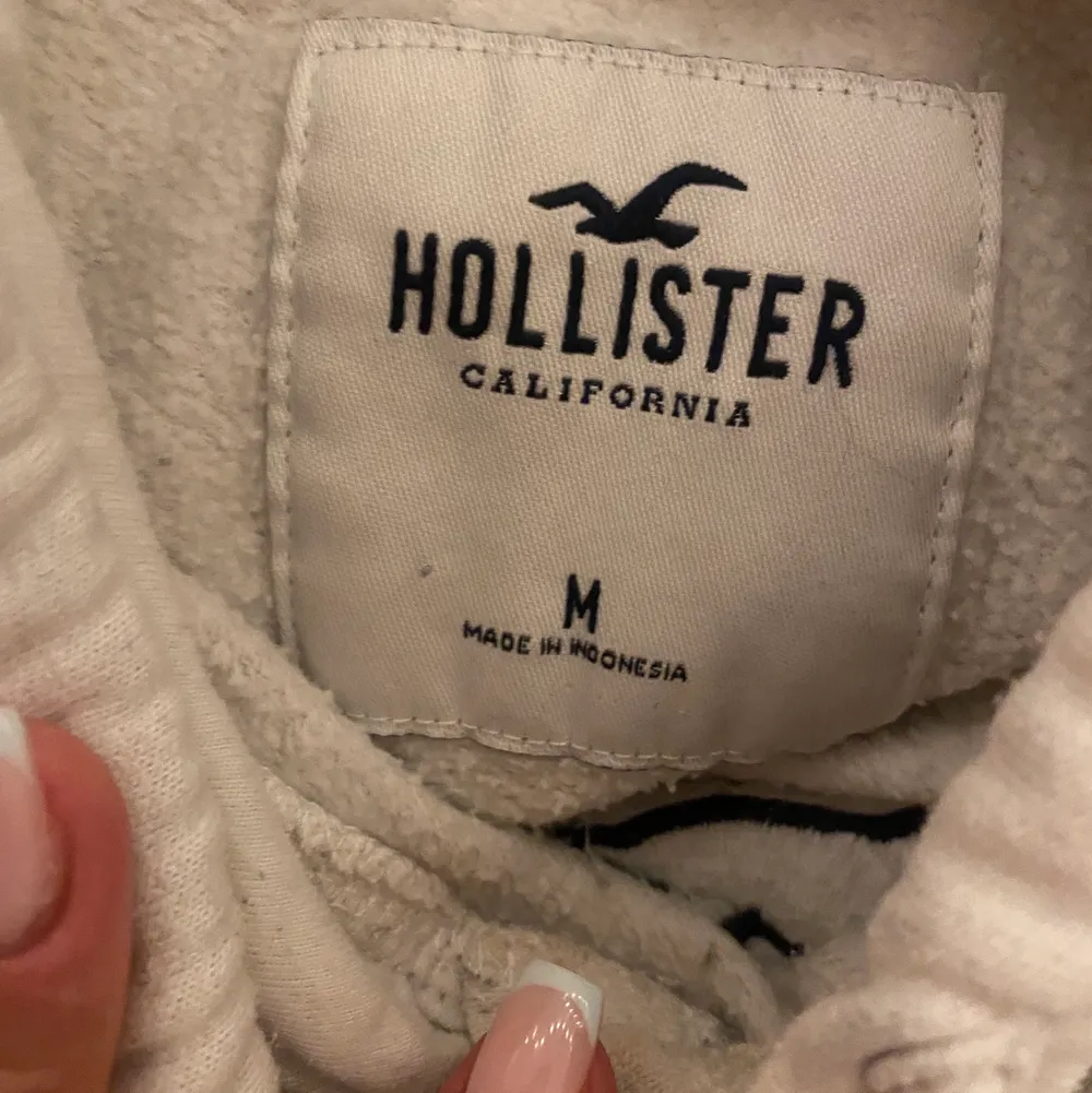 Vit hollister hoodie med marinblått tryck. Något nopprig, vilket syns på bilderna 💗. Hoodies.