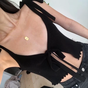 svart topp - svart topp som man knyter där fram och på axelbanden, fin kvalité o knappt använd. frakt 52kr med frimärken