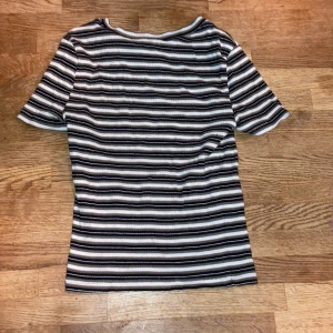  T-shirt  -  Jag säljer den för att den är lite för kort för mig. Det är en t-shirt som är grön vit och svart .