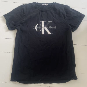 Calvin Klein  - Säljer min CK t-shirt då den inte kommer till användning längre. Den är i väldigt fint skick, den är lite skrynklig nu som syns på bilden då den legat i en påse. Storleken är 16 år men skulle säga att den passar mellan S-M. Pris går att diskutera 