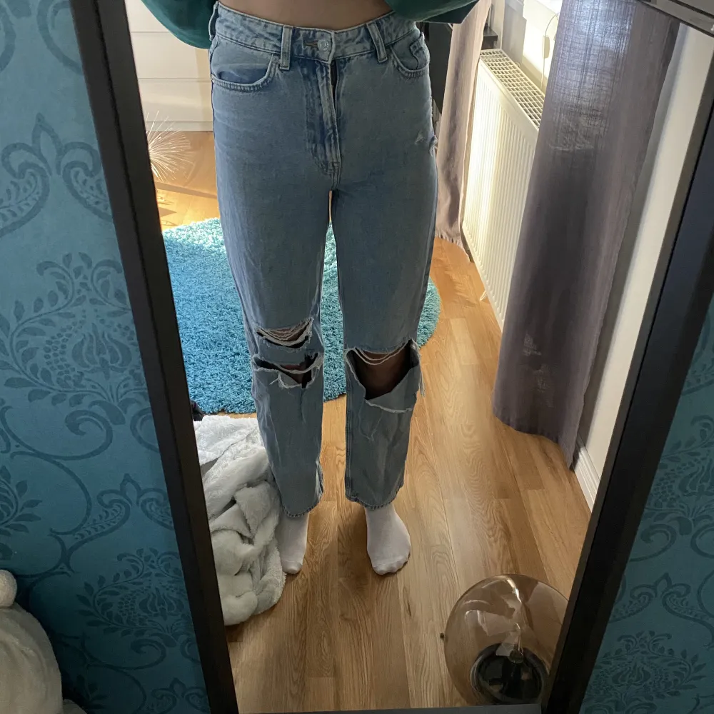 Ett par högmidjade blåa jeans med hål på knäna. Säljs då de är för korta på mig som är 173 cm. Bra skick, inte mycket använda. . Jeans & Byxor.