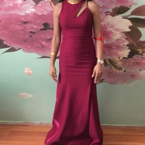 Cocktail klänning  - Vinröd cocktail klänning fin i skick använd några timmar bara, jag är 165cm lång och klänningen var fortfarande lång på mig fast än jag hade högaklack, de fina detaljen på axlarna gör hela klänningen+längden perfekt för en festlig dag