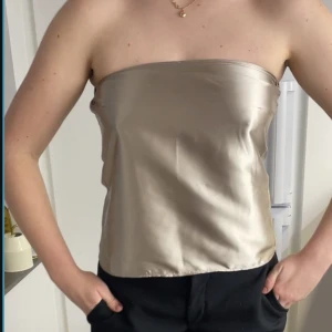Bandeau topp i champangefärg  - N.o. 2 i färgen champagne! Bandeau topp i satintyg. Vid intresse/frågor tveka ej att höra av dig!:)
