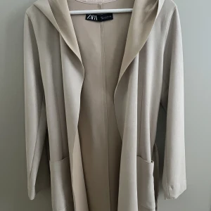 Tunn kappa - Zara - Säljer en beige kappa/kofta från zara.  Rätt tunn i materialet.  Aldrig använd.