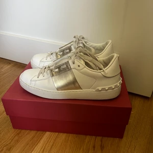 Valentino Garavani open sneaker guld 36  - Guldiga valentinosneakers strl 36, STORA i storleken, passar 37! Använda en del men med kärlek och omtanke. Någon repa framme vid tårna men inga andra skador. Box, dustbag, certifikat, extra skosnören medföljer! Frakt tillkommer på 99kr spårbar/116kr rek!