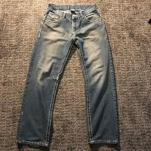 Ett par True Religion jeans i mycket bra vintage skick förutom att lite av outline stitchingen gått upp! Storlek 32 passar folk runt 1,70cm. Kontakta mig vid frågor, fler bilder eller intresse! Tar INGA Köp Via KÖP NU funktionen.