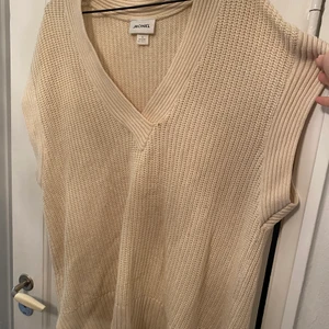 Krämvit stickad väst - Krämvit stickad väst oversized. Ett litet hål men syns knappt, se bild. 