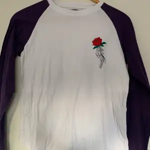 Långärmad tröja från märket STAY med en skeletthand som håller i en ros. Endast använd 1 gång. 