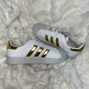 Adidas skor - Aldrig använda adidas skor med guld stripes, storlek 38 men skulle säga att den passar bättre på en 39