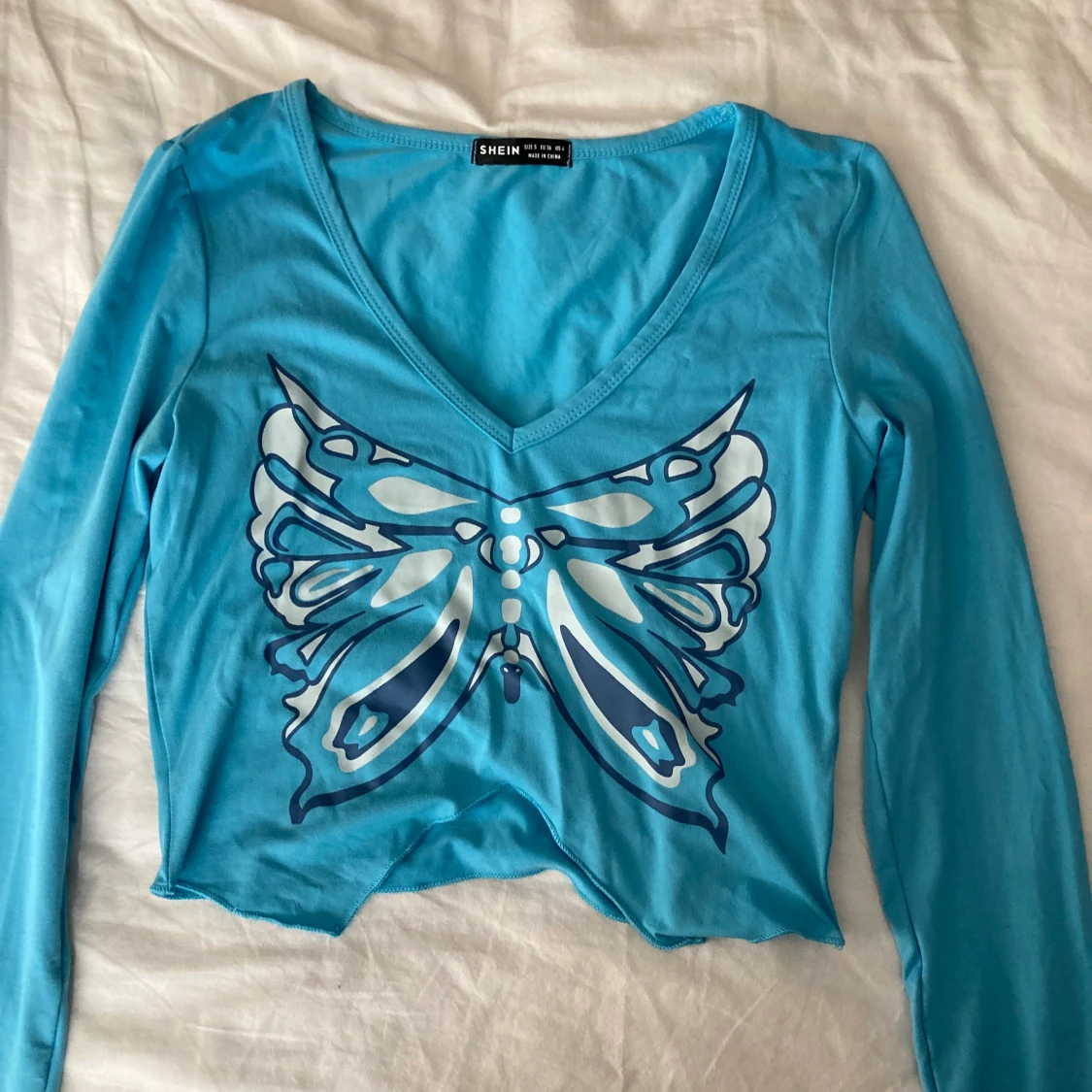 Blå topp med en fjäril på - 91