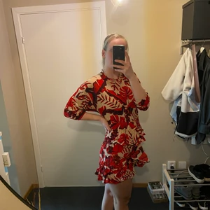 Blommig röd klänning - Oanvända klänningar. Finns i strlk 42 och 44. Jag är 182cm lång och den är lite kort. Köpte den för 299 och säljer den för 150.