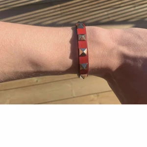 Valentino armband - Rött Valentino Garavani-armband i nyskick. Kommer med alla orginaltillbehör, box, lappar, dustbag, kvitto, extra nitar. Frakt tillkommer (Spårbar 66kr)
