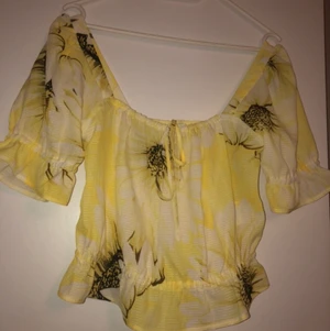 Gul blommig topp - Gul blommig topp med knytning framtill och puffärm