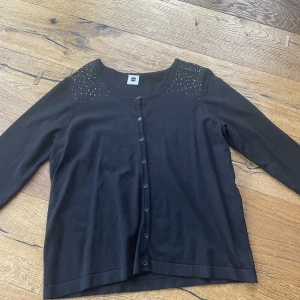 svart kofta - svart kofta med fina stenar på axlarna 
