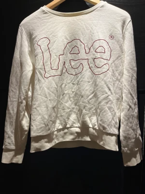 Sweatshirt  - Vit sweatshirt från LEE med vinröd text på. Väldigt fint skick då i princip aldrig använd. Köpt för 679kr.