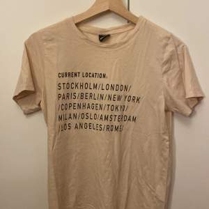 Säljer denna t-shirt med text från Gina tricot. Det som står är olika städer. Tröjan är i väldigt fint skick och jag säljer för att den inte riktigt är min stil. Tröjan är bekväm och har inga skador. 