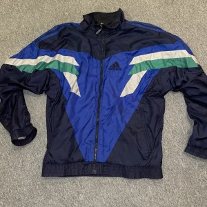 adidas vindjacka  - Adidas vindjacka oklar storlek M eller L men passar båda. Bra skick, men en dragkedja är sönder. Utöver det bra och relativt oanvänd. 