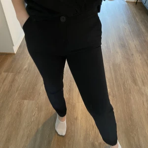 Kostymbyxor  - Dessa svarta ”kostymbyxor” är från Ginatricot och är använda men fortfarande i fint skick. Finns en fejk ficka på baksidan och två vanliga framfickor. Dessa byxor sitter jättefint på men har blivit för små för mig. Är 152 cm🤎