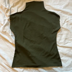 Grön topp - Grön topp som sitter tajt på med guldiga nitar på sidan!💓💖💓kan posta🧚‍♂️🧚‍♂️