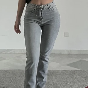 Gråa jeans  - Ett par högmidjade jeans, aldrig använd i storlek 36. Slits nertill. 