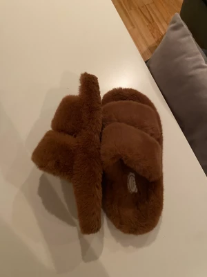 Mjuka tofflor  - Går att använda inomhus/utomhus! Tror det är meningen att de ska användas utomhus💕 färgen är åt det mer mörkbruna hållet! Använda ett fåtal gånger! Från NA-KD. Kostade 400 kr nypris!