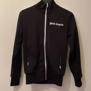 Palm angels tröja - Palm angels track top Helt oanvänd med alla tags kvar. köpt i Frankrike för ungefär ett halvår sedan.  Storlek: xs.  Köpt för nypris på 4500kr.  Qr kod finns.