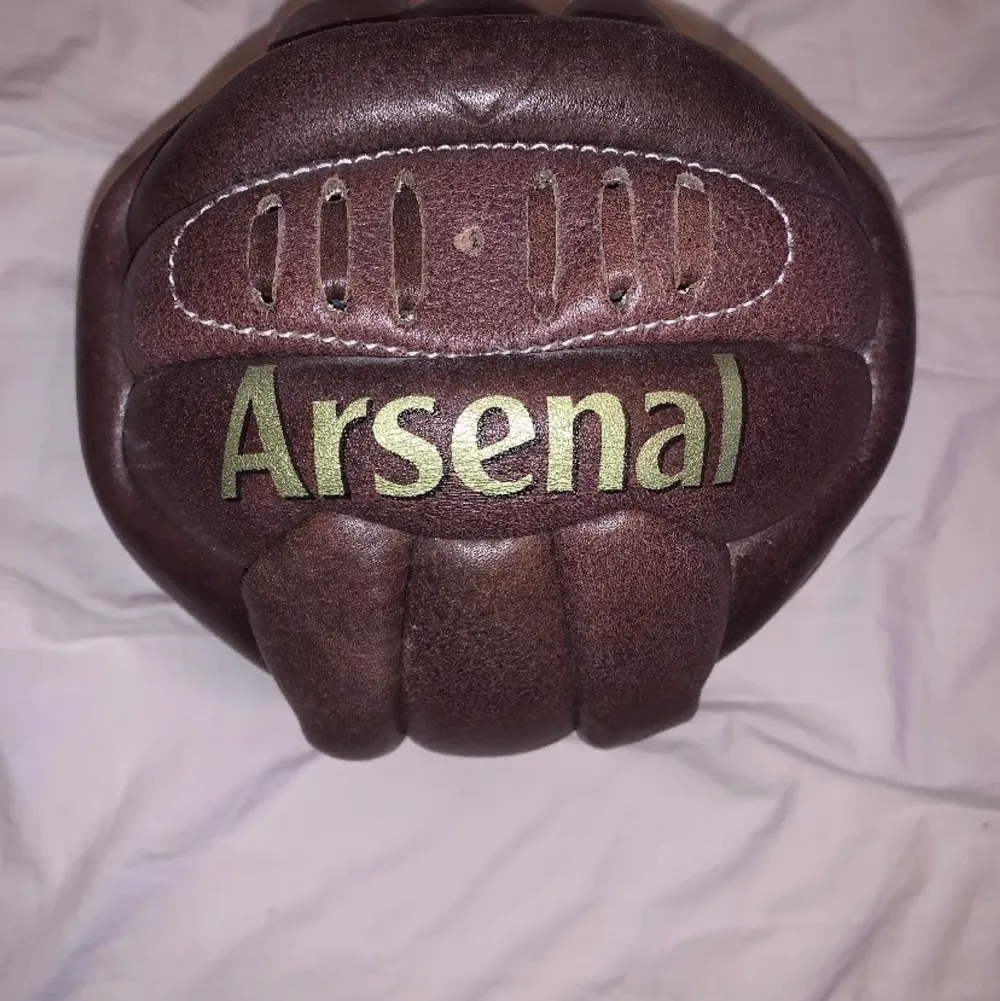 Arsenal samlar objekt köpt från arsenals fanshop (ej fylld med luft behövs pumpas upp) Läderboll i gammaldags stuk,med arsenal tryckt på bollen i guld  (Äkta läder). Övrigt.