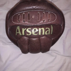 Arsenal gammaldags läderboll - Arsenal samlar objekt köpt från arsenals fanshop (ej fylld med luft behövs pumpas upp) Läderboll i gammaldags stuk,med arsenal tryckt på bollen i guld  (Äkta läder)