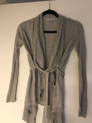 Kofta - Härlig tunn kofta, passar till det mesta:) Ljusgrå. Storlek xs men passar xxs. 