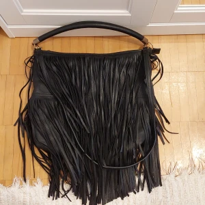 Svart väska H&M - Svart väska från H&M med dragkedja. Det finns flera fack på insidan. Har använts men är i bra skick.   • Betalning sker via Swish  • Hämtas upp i Vällingby