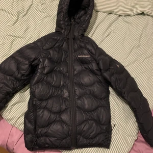Peak Performance Helium down hood jacket - Säljer denna Jacka från Peak performance ” Helium down hood jacket,black STRL S”. Köpte för cirka 2 år sedan och bara använt ungefär 5 gånger. Säljer för att den inte kommer till användning. Super fin kvalitet. Köptes för 2600kr. Sälj för 1500kr