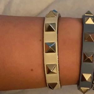 Valentino armband  - Säljer mitt super snygga beiga valentino armand, finns täcken på användning men forfarande mycket gott skick. Box, äktehetsbevis, extra nitar osv. Finns!💗🫶🏻 !!!SÄLJER DIREKT FÖR 1600kr!!!