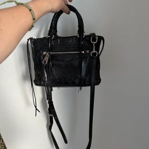 Rebecca Minkoff väska - En crossbody bag från Rebecca Minkoff i deras regan modell . Väskan är i fint skick, men lite synligt slitage på den främre haken som håller fast crossbody bandet. 