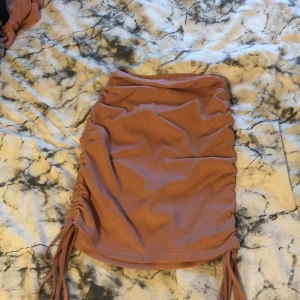 Knytbar kjol - En smutsrosa kjol med band vid sidan som man kan spänna, från shein. Använd en gång. Fint skick. Frågor?  Skriv i DM  Köparen står för frakten. 