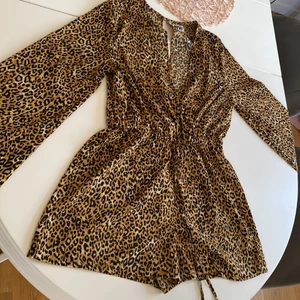leopard jumpsuit - Långärmad leopard jumpsuit med resår/knyte i midjan och knäppe i nacken. Endast prövad.  St 40 fungerar även som st 38. Köparen står för frakt.