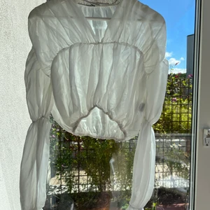Luftig vit mesh-crop top - Crop top med en sorts ballongärmar. Mycket finare på än på bild. Strl XS. I fint skick.