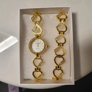 Guldig klocka med armband  - Aldrig använt. Två armband då den ena även har en klocka. Köparen står för porto, kan mötas i halmstad 